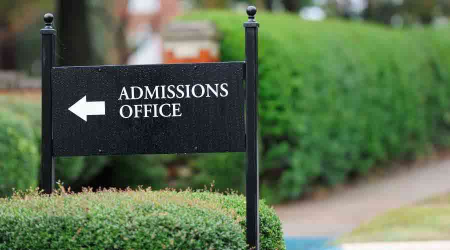 sign pointing to college admission office