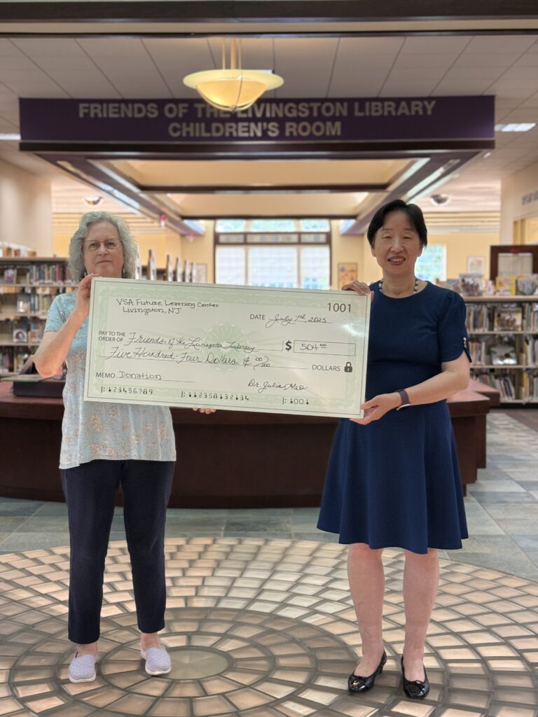 Dr. Julia gives donation check to Friends of the Livingston Library member Anita Mintz